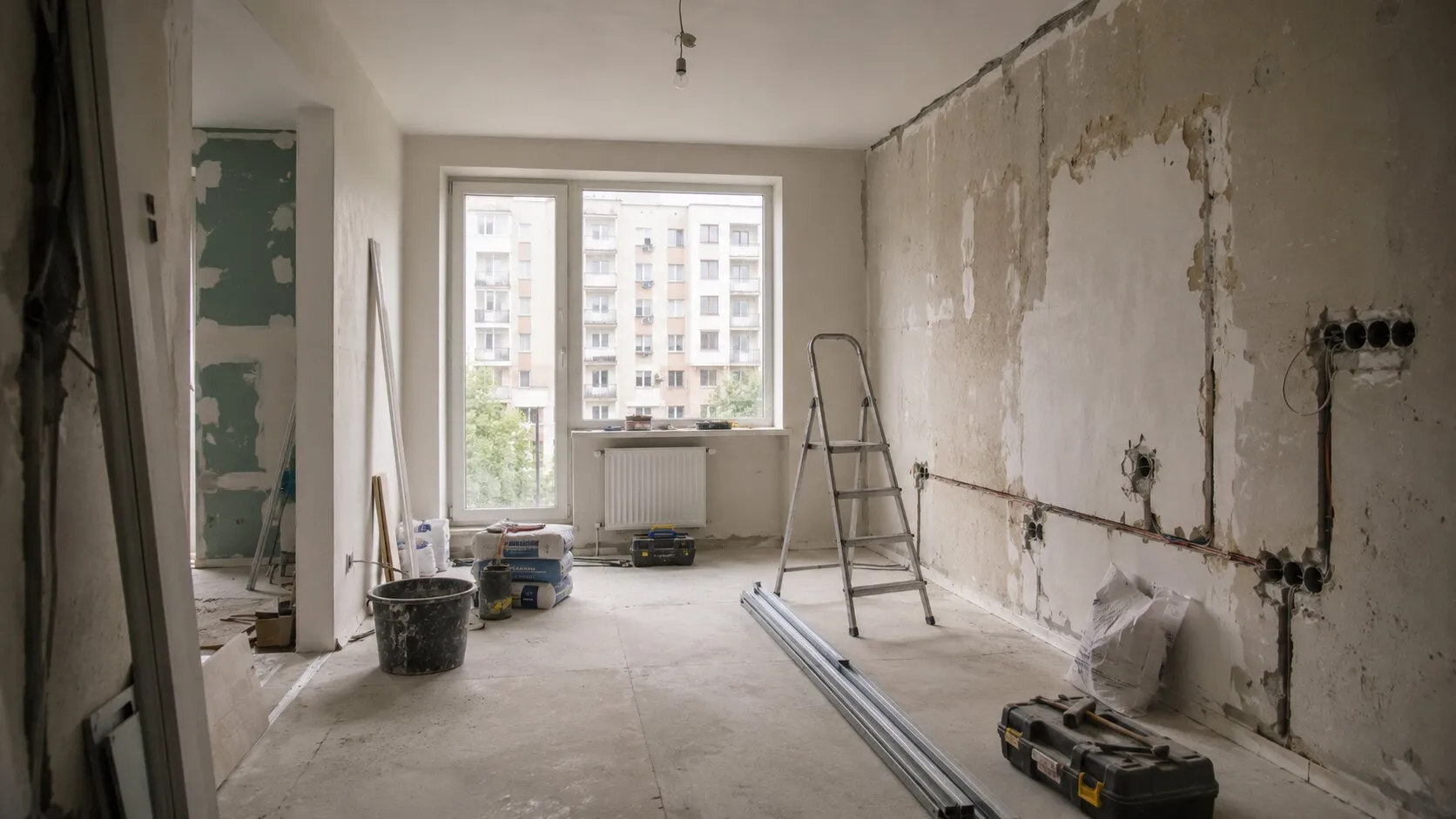 Apartament aflat în renovare, cu pereți decopertați, instalații pregătite și materiale de lucru