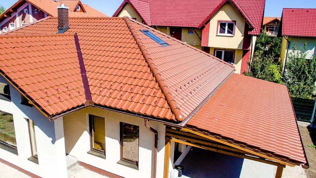 Casă parter cu acoperiș din țiglă ceramică Tondach în nuanță naturală, cu coame, dolii, coș și fereastră de mansardă.