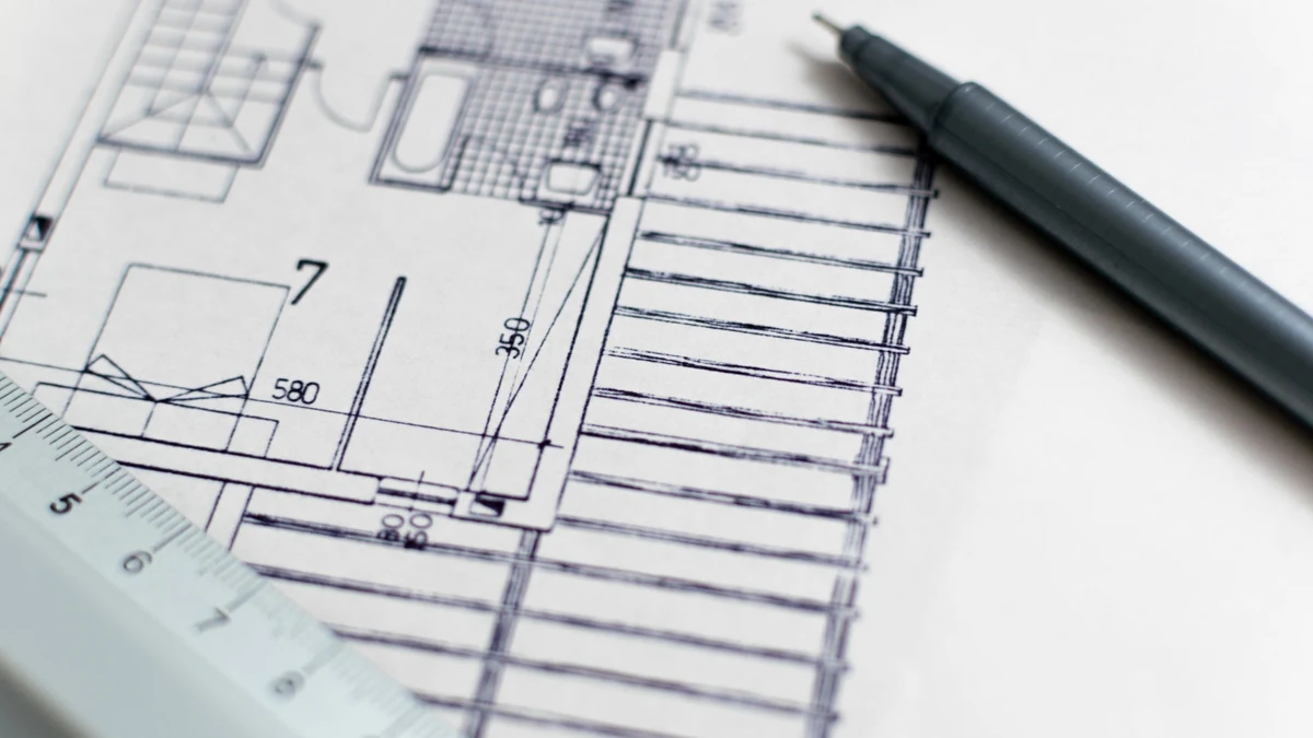 Plan de arhitectură cu dimensiuni, riglă și instrument de desen.