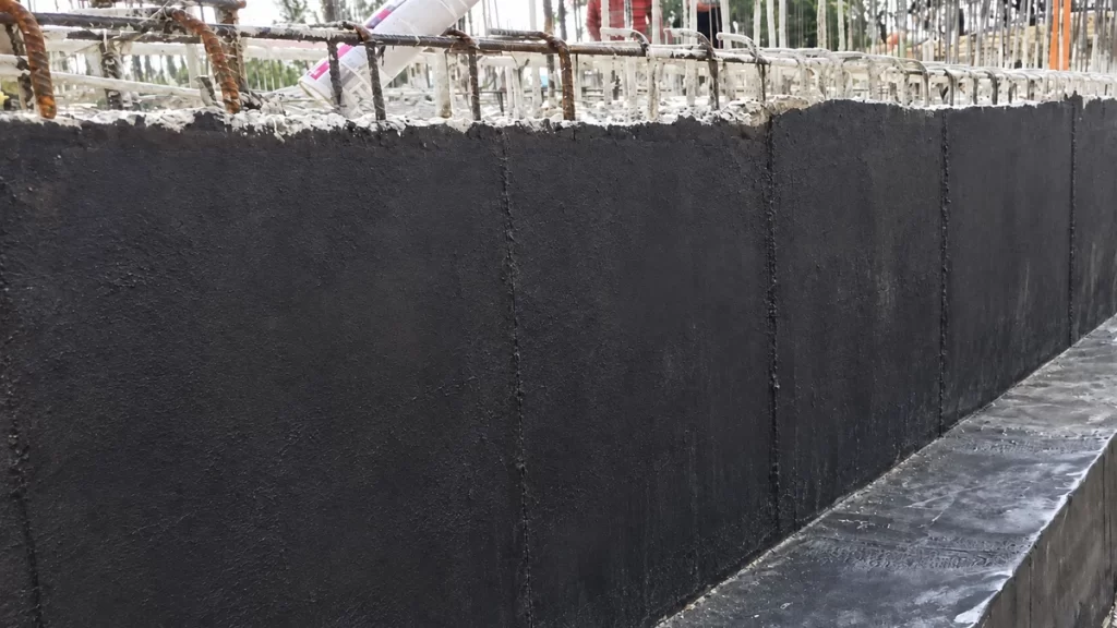 Hidroizolația fundației cu membrană neagră montată în fâșii verticale